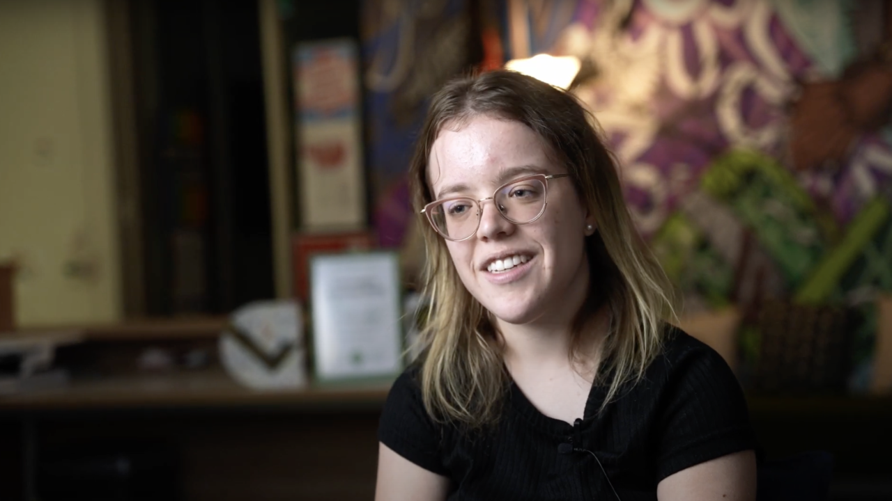 Julie, a person of short stature who wears glasses, speaking to the camera.